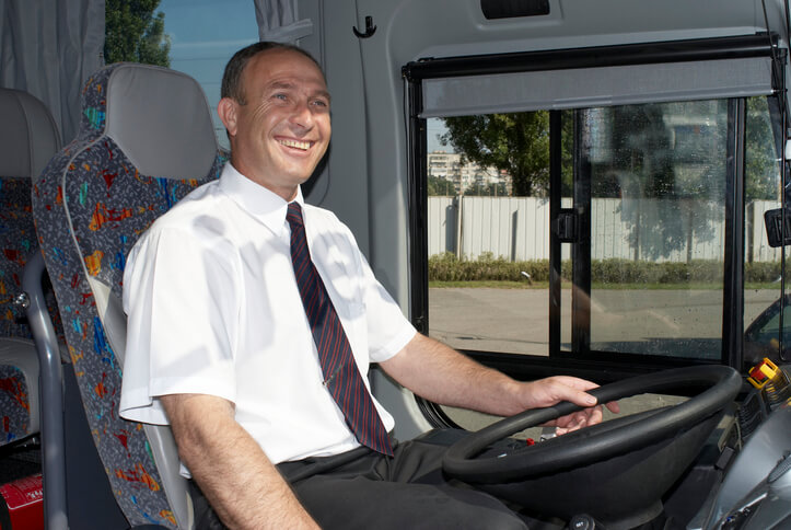 A happy bus driver at work after having completed his CDL DOT Medical Examination Requirements.