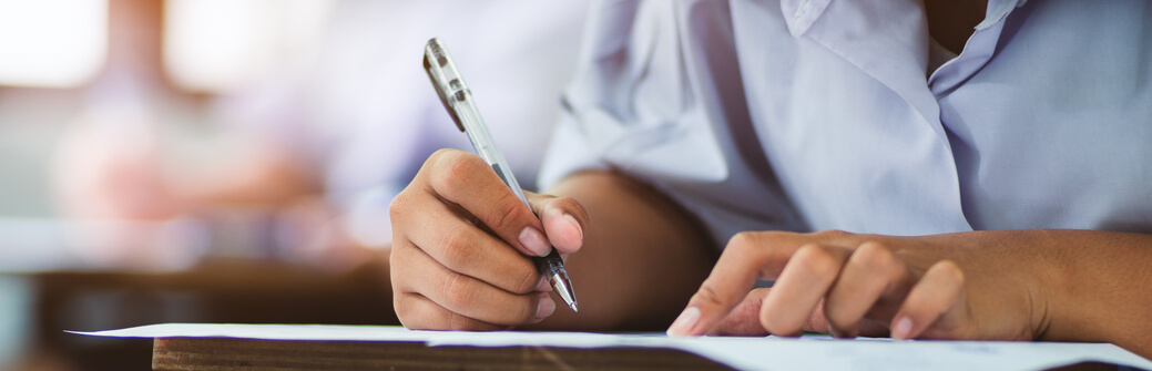 A close up of a student taking a written exam.
