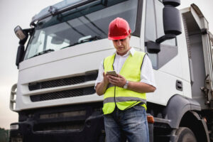 A truck driver using a mobile app to perform a pre-trip inspection